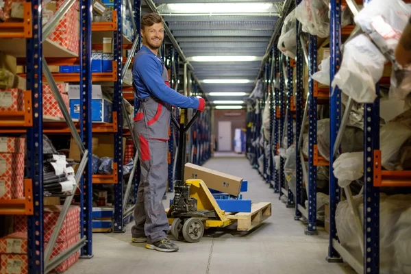 Loader using hand pallet truck in a warehouse — Stock Photo, Image