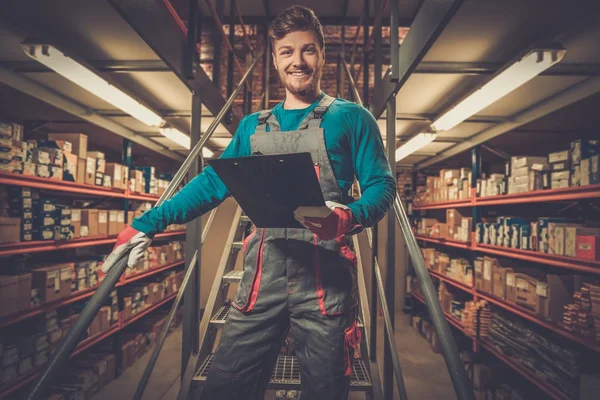 Werknemer op een magazijn voor auto-onderdelen — Stockfoto