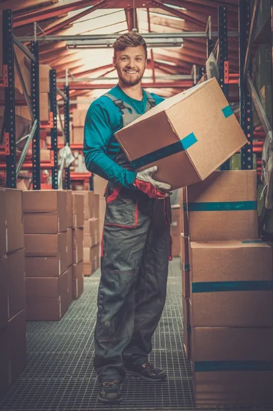 Портер перевозит коробки на складе — стоковое фото