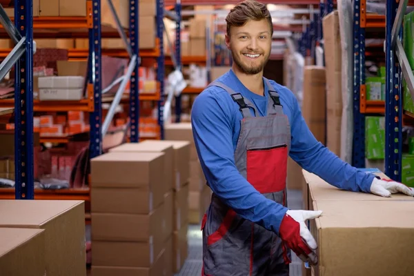 Gepäckträger trägt Kisten in einem Lager — Stockfoto