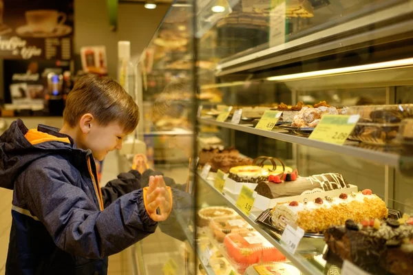 Little boy near display with cakes — Stock Photo, Image
