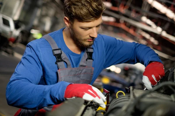 Mechanic checking under hood in a workshop — Stock Photo, Image