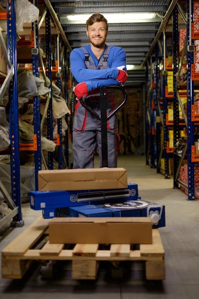 Lader met behulp van hand pallettruck in een magazijn — Stockfoto