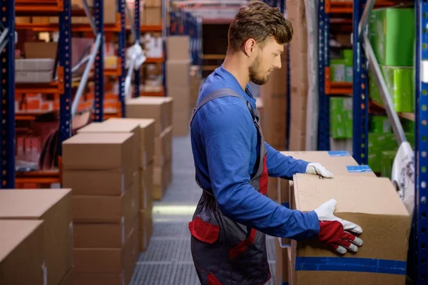 Porter carrying boxes in a warehouse — Stock Photo, Image