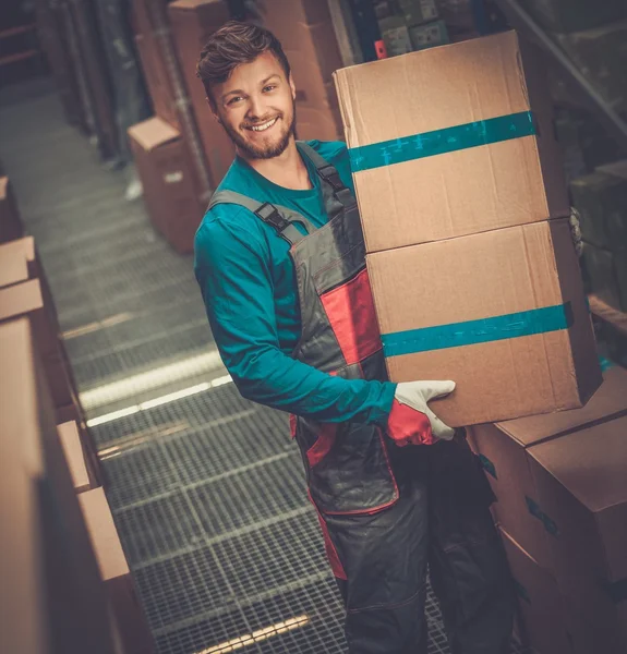 Gepäckträger trägt Kisten in einem Lager — Stockfoto