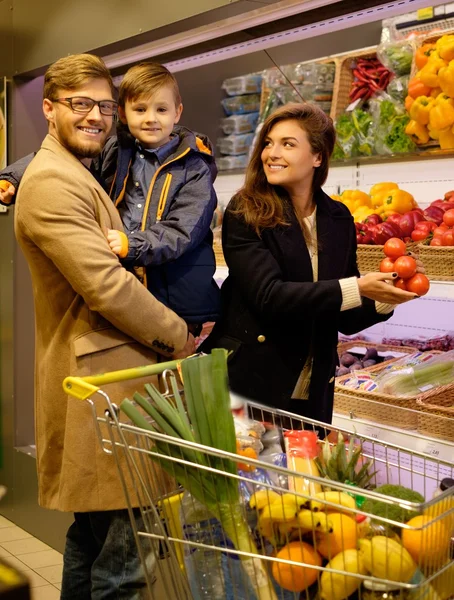 Молодая семья в продуктовом магазине — стоковое фото