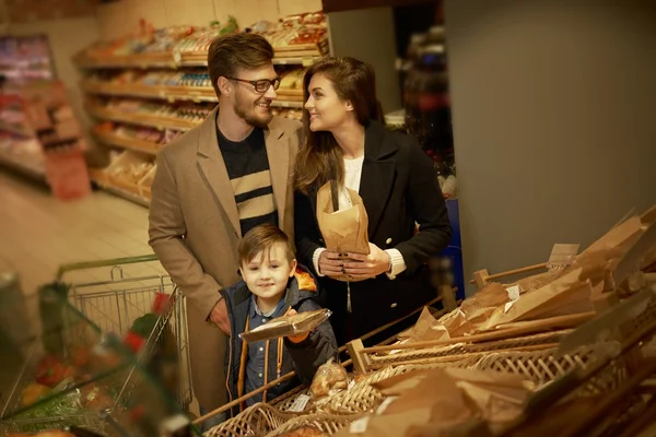 Семья выбирает хлеб в продуктовом магазине — стоковое фото