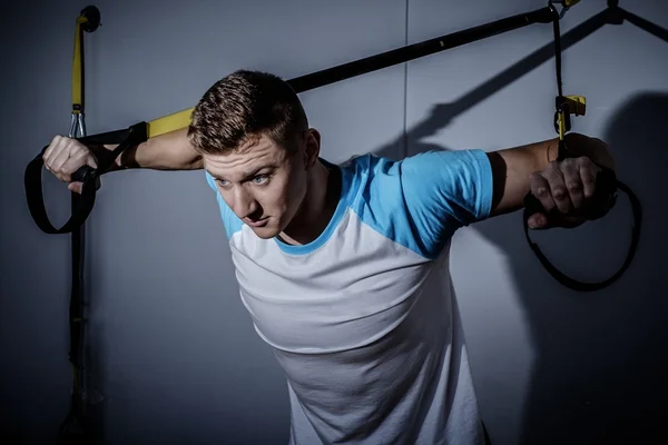 Man during workout with suspension straps — Stock Photo, Image