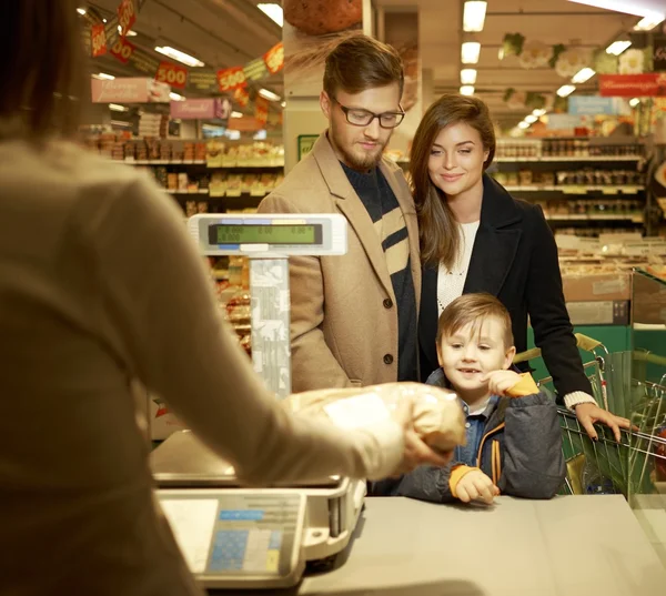 Family buying bread in a grocery store — Stock Photo, Image