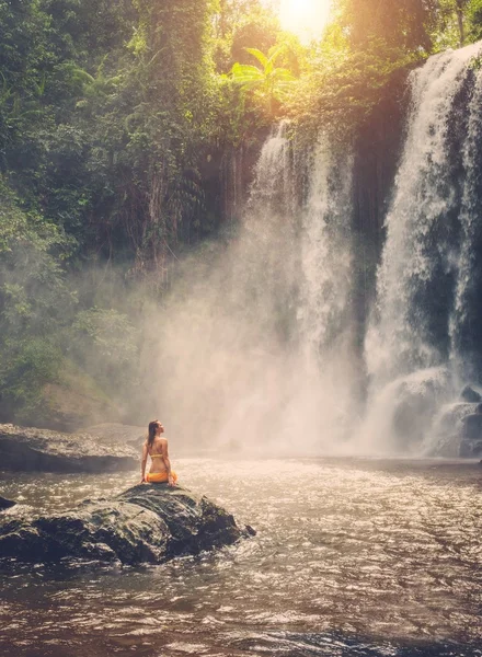 Belle femme assise près de la cascade — Photo