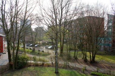 Ağaçların arkasında bina çok katlı