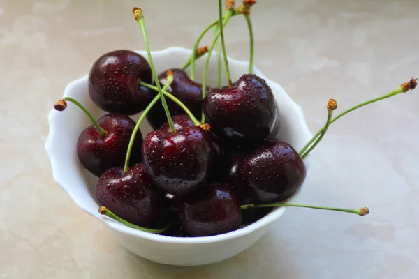 Las cerezas rojas oscuras en el tazón blanco — Foto de Stock