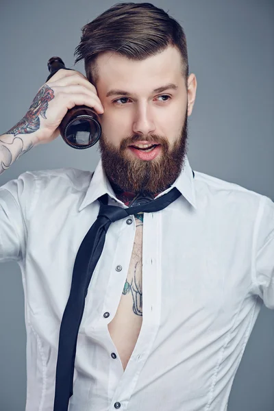 Brodaty mężczyzna z tatuażami na ramieniu. — Zdjęcie stockowe