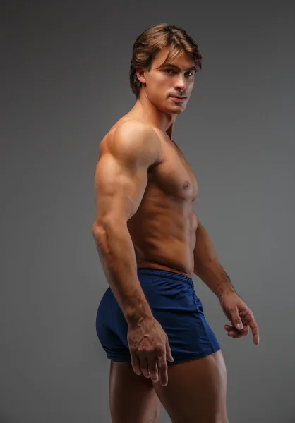 Bar överkropp muskulös man i en blå shorts. — Stockfoto