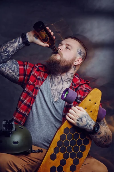 Бородатый татуированный мужчина пьет пиво — стоковое фото