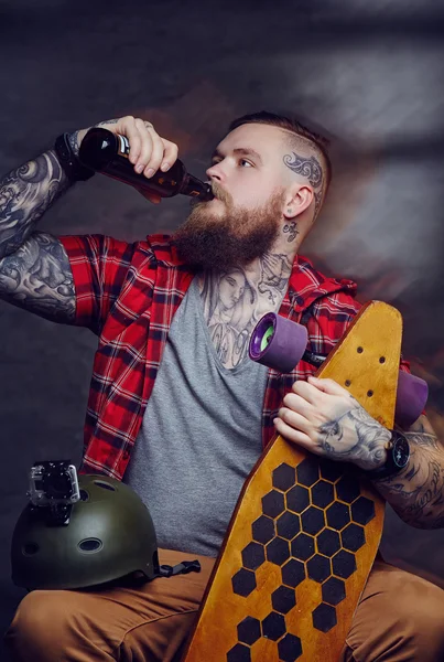 Бородатий татуйований чоловік п'є пиво — стокове фото