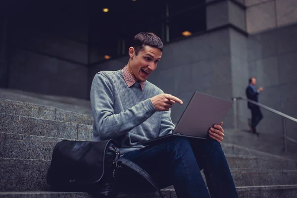 Smiling young man with laptop — Stock Photo, Image
