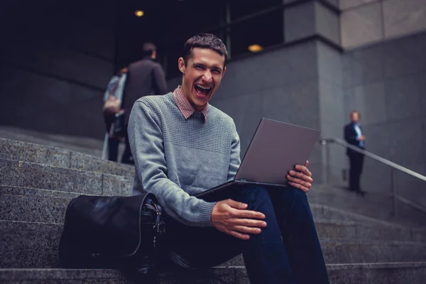 Sourire jeune homme avec ordinateur portable — Photo