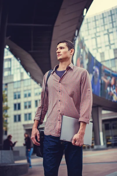 Man holds laptop on the street — Stock Photo, Image