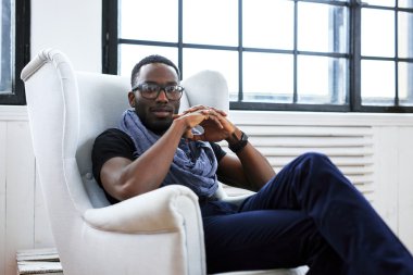 adam beyaz bir sandalyede oturur.