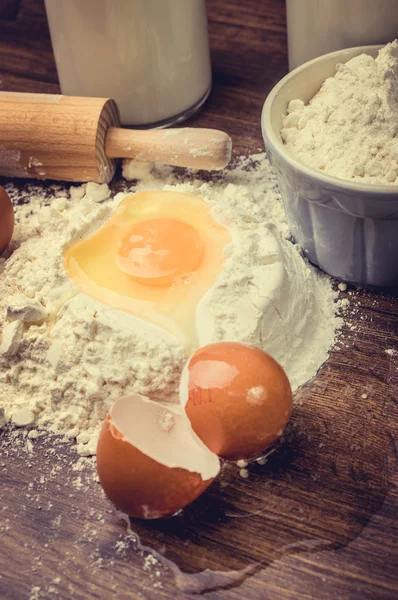 Ovos e farinha em uma mesa . — Fotografia de Stock