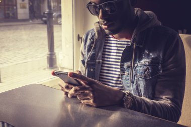 adam akıllı telefon kullanarak güneş gözlüğü.