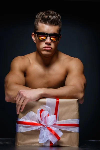 Hombre musculoso con caja actual . — Foto de Stock