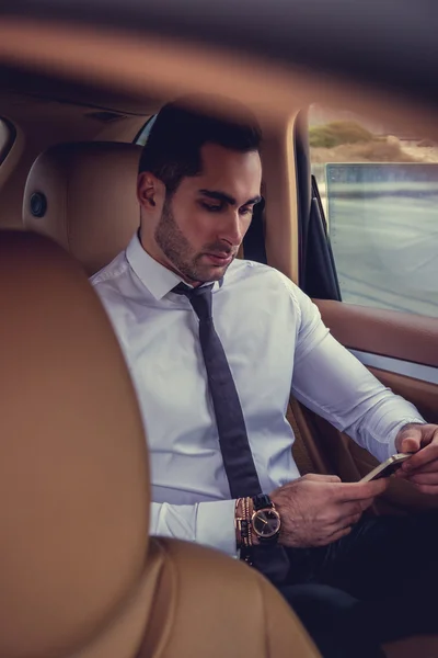 Empresário com smartphone no carro . — Fotografia de Stock