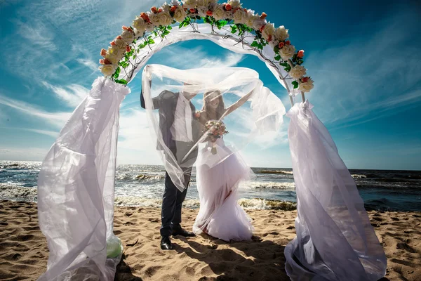 Felices recién casados en una playa — Foto de Stock