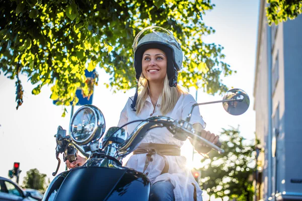 Lächelnde blonde Frau auf Motorroller — Stockfoto