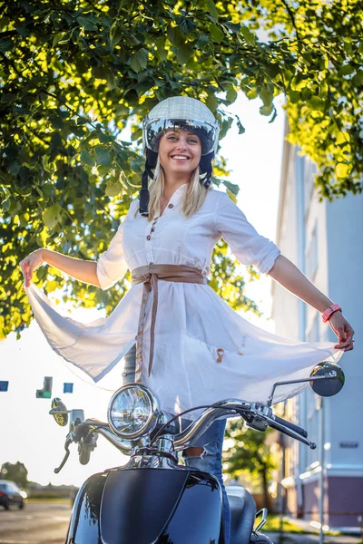 Lächelnde blonde Frau auf Motorroller — Stockfoto