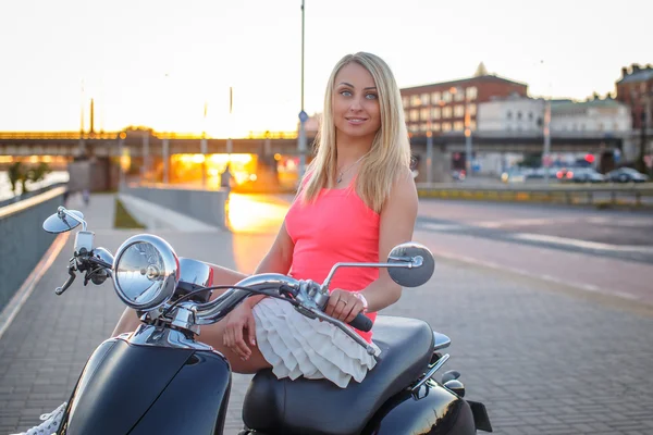 Vrouw in roze t-shirt met moto scooter — Stockfoto