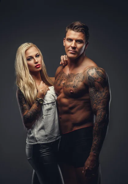 Modern tattooed couple posing in a studio