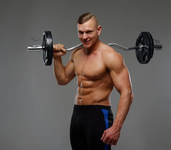 Musculoso hombre sosteniendo la barra — Foto de Stock