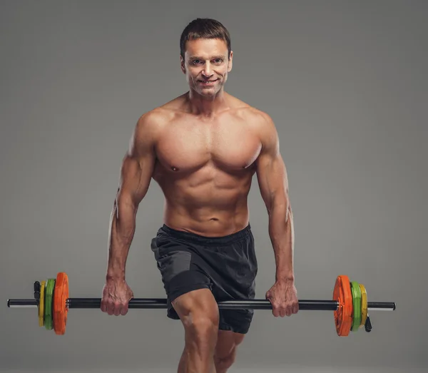 Muskulöser Mann mittleren Alters mit Langhantel. — Stockfoto