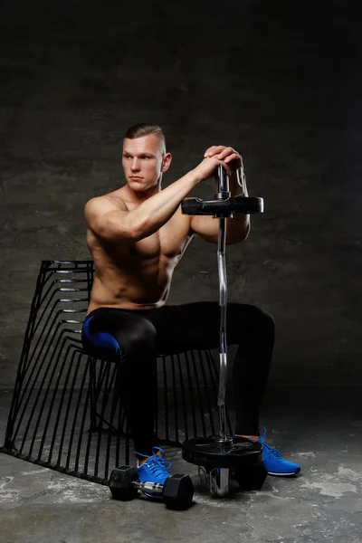 Man posing in studio with barbell — Stock Photo, Image
