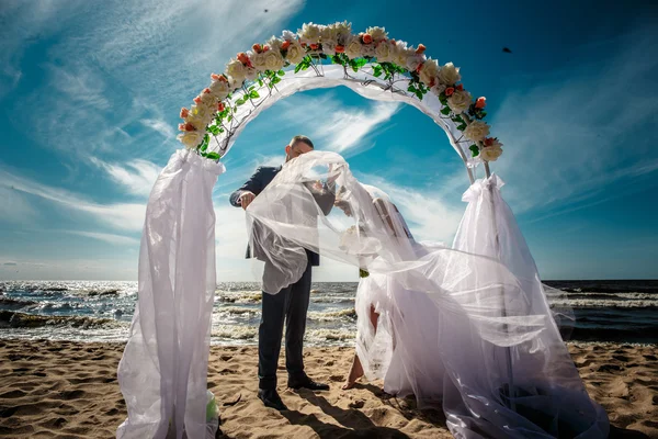 Recém-casados felizes em uma praia — Fotografia de Stock