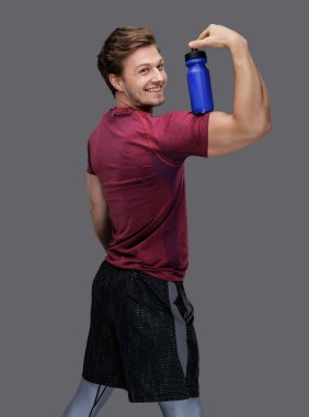 adam şişe suyu tutar.