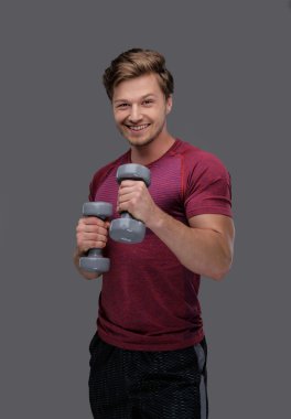 adam dumbbells çifti tutar