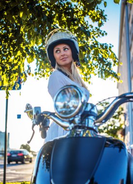 Moto scooter üzerinde gülümseyen sarışın kadın