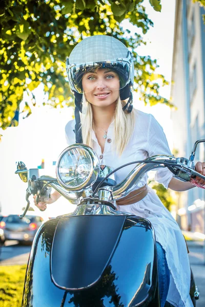 Lachende blonde vrouw op moto scooter — Stockfoto