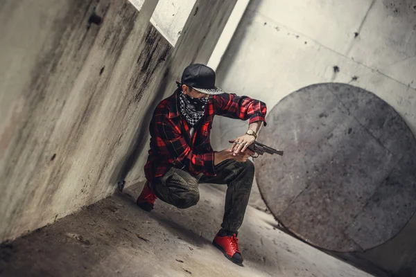 Man in a mask holds gun — Stock Photo, Image