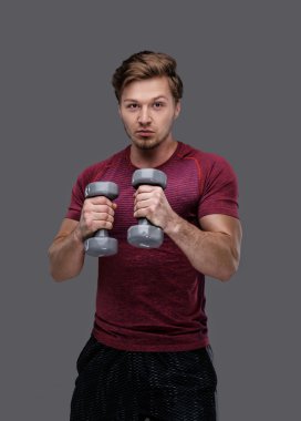 adam dumbbells çifti tutar