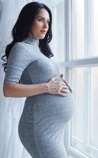 Gri elbiseli hamile esmer kadın — Stok fotoğraf