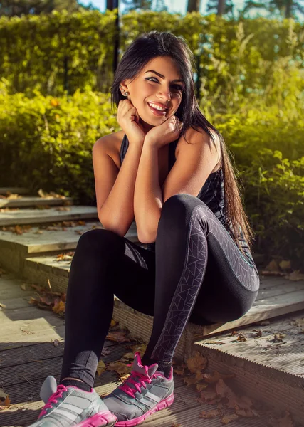 Fitness woman sits on steps — Stock Photo, Image