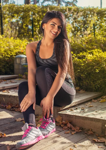 Fitness woman sits on steps — Stock Photo, Image