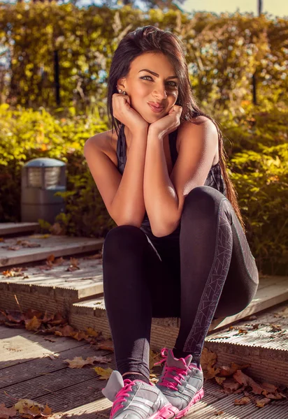 Fitness woman sits on steps — Stock Photo, Image