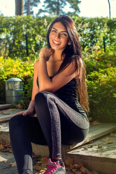 Fitness woman sits on steps — Stock Photo, Image