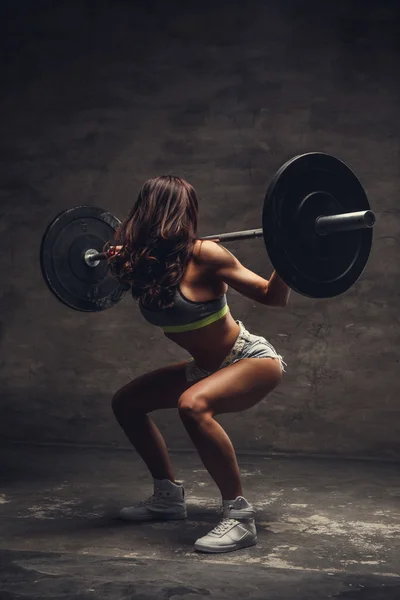 Feminino fazendo agachamentos com barra — Fotografia de Stock