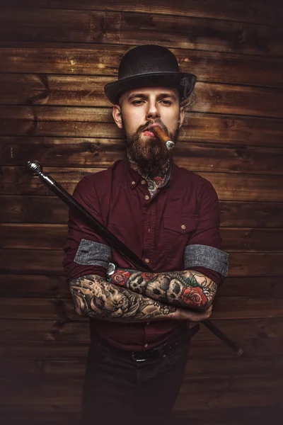 Bearded tattooed guy with walking stick — Stock Photo, Image